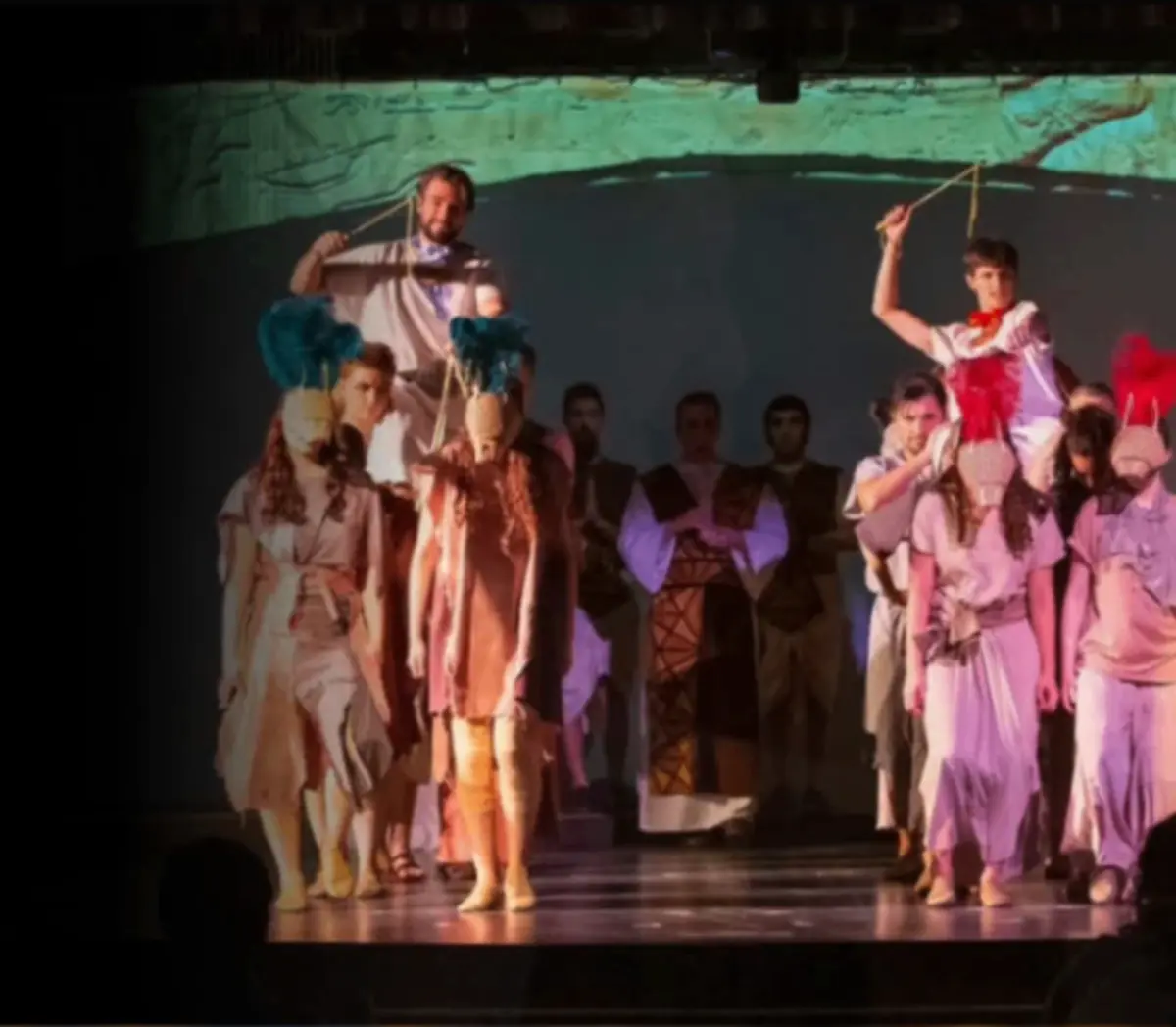 Actors performing together on a warmly lit stage